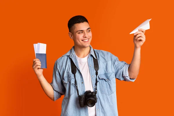 Chico juguetón con cámara con pasaporte y avión de papel — Foto de Stock