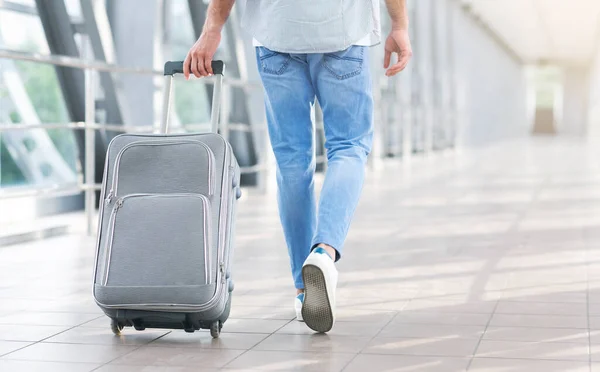 Hombre irreconocible caminando con la maleta en el aeropuerto, yendo a la puerta de embarque — Foto de Stock