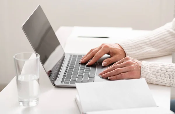 Praca online i praca na komputerze. Na stole jest laptop, notebooki, szklanka wody — Zdjęcie stockowe