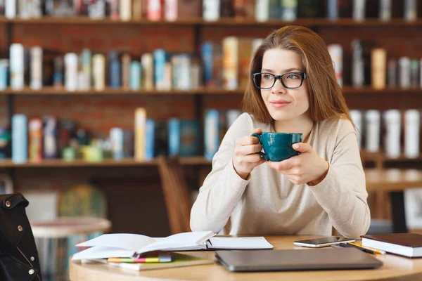 Привлекательная девушка пьет утренний кофе в кафе и наслаждается временем в кафе — стоковое фото
