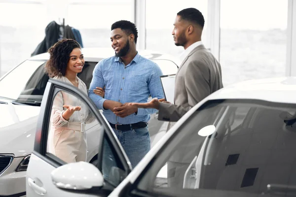 Couple Choosing Car Consulting With Professional Auto Salesman In Dealership — Stock Photo, Image