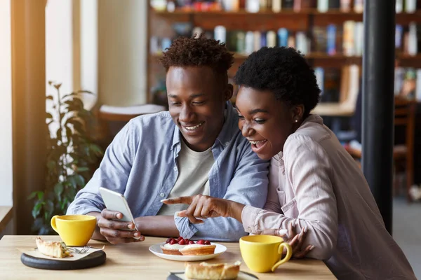 ロマンチックな時代だ。美しいアフリカ系アメリカ人のカップルとスマートフォンの日付でコーヒーショップ — ストック写真