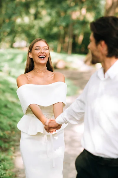 Feliz boda pareja caminando sosteniendo las manos al aire libre en el parque natural — Foto de Stock