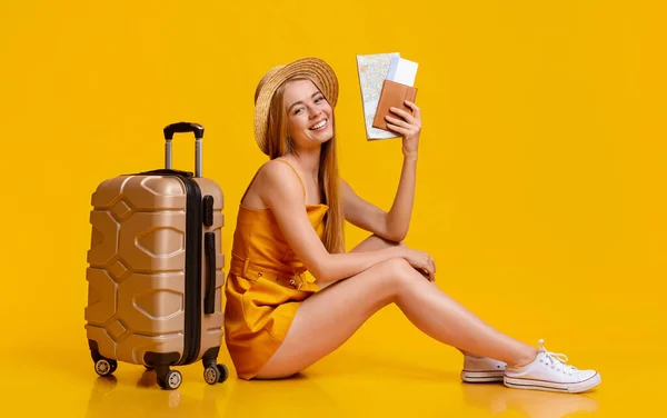 Concetto di assicurazione di viaggio. Giovane ragazza seduta sul pavimento con valigia e biglietti — Foto Stock