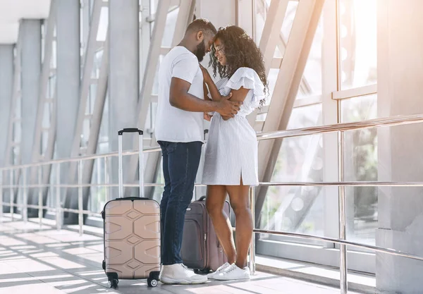 Retrato de pareja negra cariñosa abrazándose en el corredor del aeropuerto — Foto de Stock