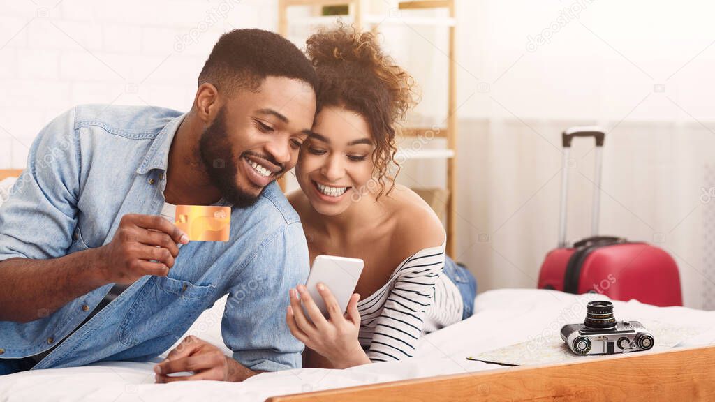 African Couple Using Smartphone And Credit Card In Bedroom, Panorama