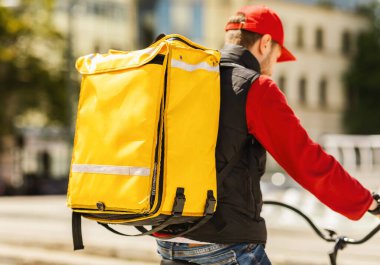 Tanımlanamayan Kurye Dışarıya Bisikletli Sarı sırt çantasıyla yemek getiriyor