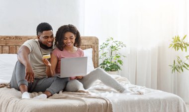 Genç Afrikalı çift internetten alışveriş yapmaktan mutlu.