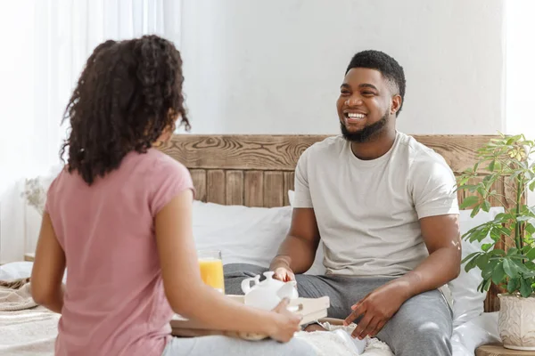陽気な黒人男性彼のガールフレンドを見て、ベッドで朝食 — ストック写真