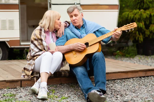 Pareja jubilada con guitarra cantando juntos cerca de su autocaravana en el camping —  Fotos de Stock