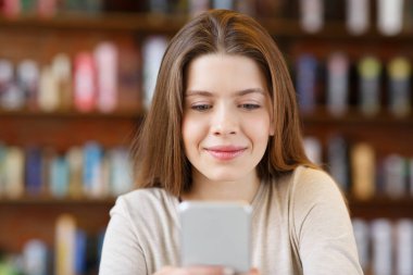 Modayı takip eden genç kız cep telefonundan mesaj atıyor.