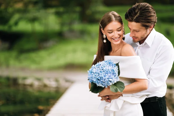 Hochzeitspaar umarmt sich im Park bei minimalistischer Zeremonie — Stockfoto