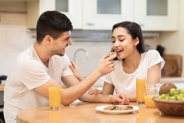 Smiling man feeding his girl, couple having breakfast together — Stock Photo, Image