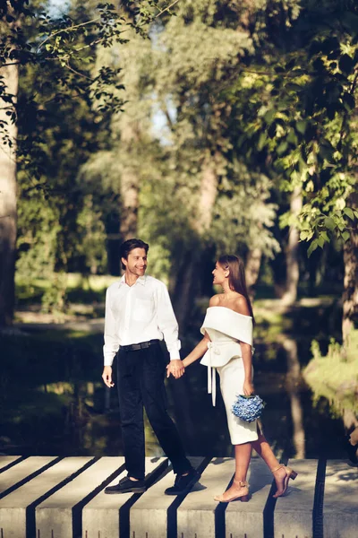 Свадебная пара ходить держась за руки в парке, вертикальный выстрел — стоковое фото
