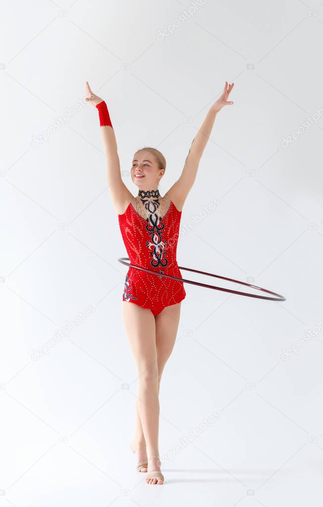 Professional rhythmic gymnastics. Artistic young girl training with hula hoop, isolated on white