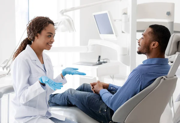 Χαμογελαστή γυναίκα οδοντίατρος γιατρός συζητά τη θεραπεία με ασθενή — Φωτογραφία Αρχείου