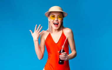 Ferahlatıcı içecek. Heyecanlı Milenyum Kızı Mayolu Parlak Yaz İçeceğinin tadını çıkarıyor