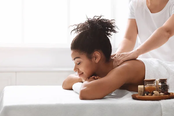 Mulher negra bonita desfrutando de massagem corporal com aromaterapia — Fotografia de Stock