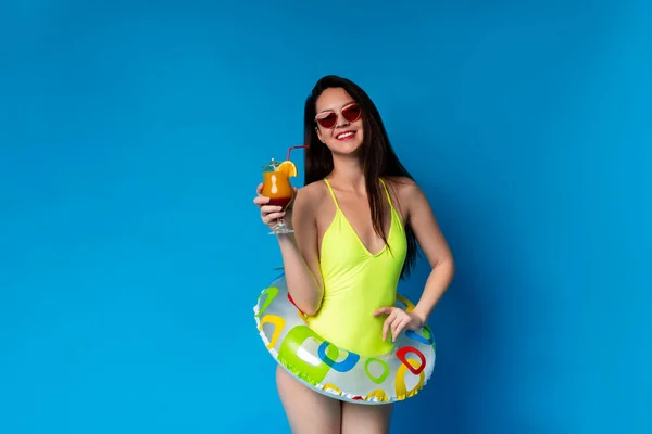 Sommer-Chil. Positive asiatische Mädchen posieren mit Cocktail und Schwimmring — Stockfoto