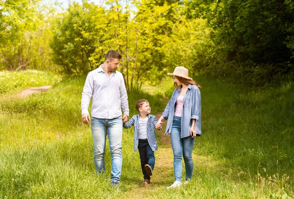 Tempi di legame familiare. Giovani genitori e il loro figlio in una passeggiata insieme in campagna — Foto Stock