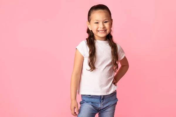 Menina asiática feliz posando e olhando para a câmera — Fotografia de Stock