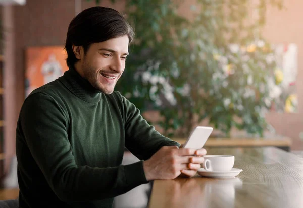 Happy businessman chatting with clients on smartphone