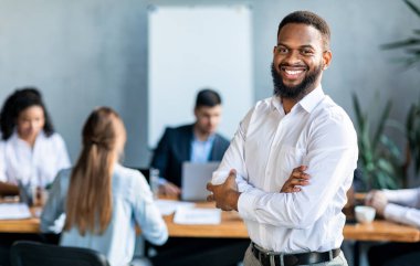 Modern Ofiste Siyahi İşadamı Kurumsal Toplantı sırasında Duruyor