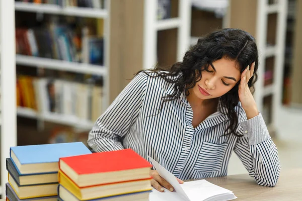 Chica latina preparándose para el examen en la biblioteca —  Fotos de Stock