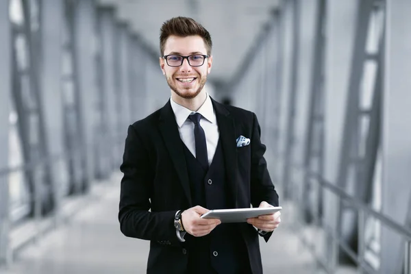 Hombre de negocios urbano sosteniendo tableta digital y sonriendo —  Fotos de Stock