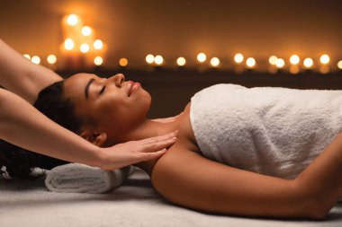 Spa 'da Afrikalı kadınların omuzlarına masaj yapan terapist.