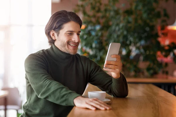 Hombre de negocios exitoso utilizando el teléfono inteligente mientras descansa el café — Foto de Stock