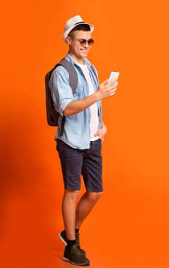 Yazlık giysiler içinde cep telefonu kullanan mutlu bir adam.