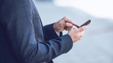 Genç girişimcinin dış cep telefonundan e-postaları kontrol etme görüntüsü