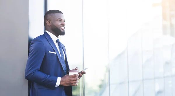 Empresario africano sosteniendo mensajes de texto de teléfonos celulares tomando café al aire libre, Panorama — Foto de Stock