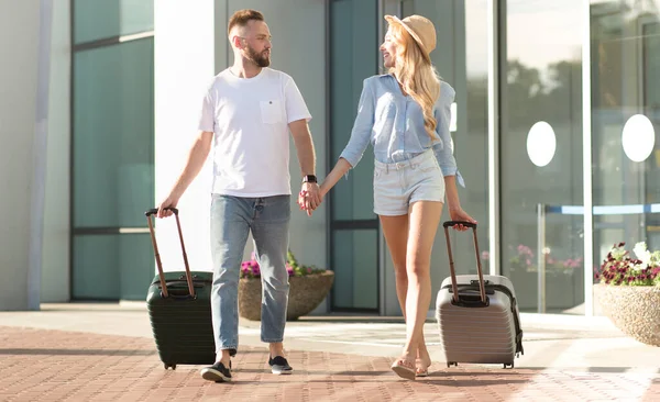 Młoda para spacerująca po lotnisku z bagażem, przestrzeń do kopiowania — Zdjęcie stockowe