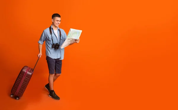 Viajero masculino con mapa de sujeción de maleta, yendo hacia espacio de copia — Foto de Stock