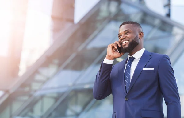 Glückliche afrikanische Unternehmerin spricht über Handy im Stehen in der Stadt — Stockfoto