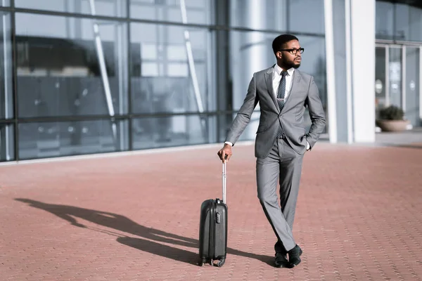 Afro-Amerikalı İş Adamı Gezgin, Bavulla birlikte açık hava havaalanı yakınlarında duruyor. — Stok fotoğraf