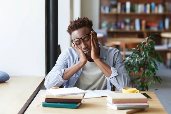 Uitgeputte Afro-Amerikaanse student maakt zich klaar voor moeilijk examen in de universiteitskantine — Stockfoto