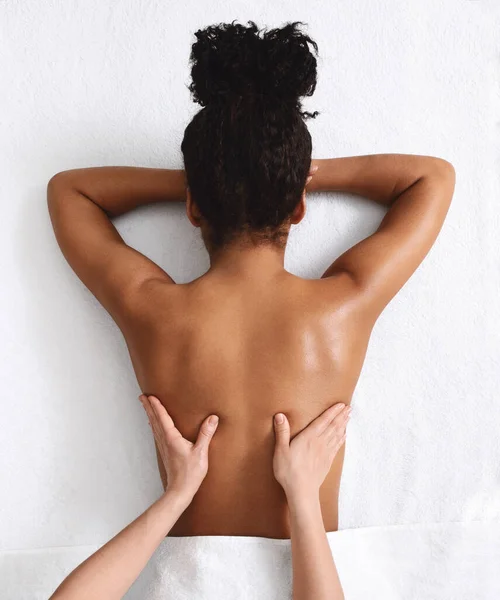 Mujer africana irreconocible teniendo masaje de espalda, fondo blanco — Foto de Stock