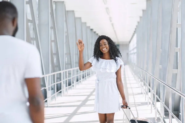 Заботливый черный мужчина встречает свою девушку в аэропорту — стоковое фото
