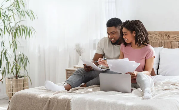 Negro hombre y mujer chequeando gastos mensuales juntos — Foto de Stock