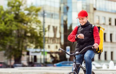Bisiklet kontrolündeki kurye şehre yemek getiriyor.