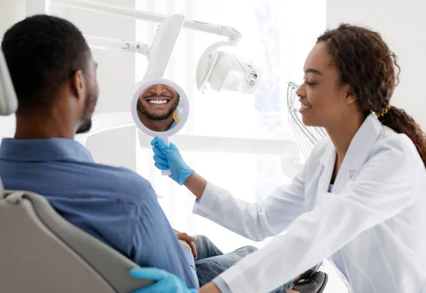 ホワイトニング治療の結果を確認するために患者のための歯科医師保持ミラー — ストック写真