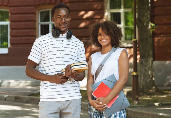 Sorrindo afro cara e menina universitários posando ao ar livre perto do campus — Fotografia de Stock