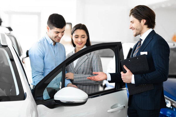 Дилер представляет пару новых автомобилей в магазине дилеров
