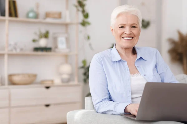 2017 년 12 월 7 일에 확인 함 . Portrait of positive Senior Lady Using Laptop at Home, Smiling At Camera — 스톡 사진