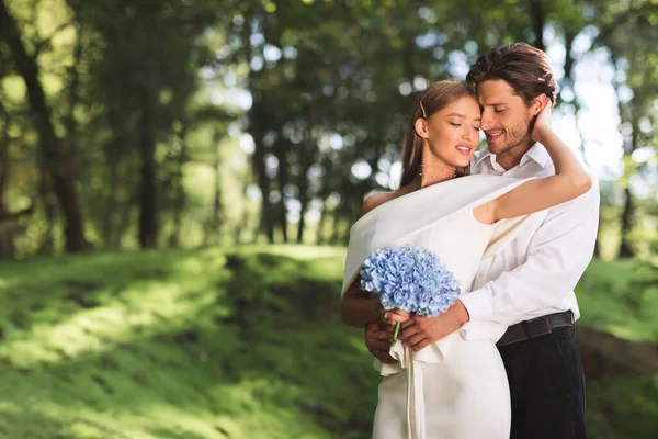 Loving Couple Hugging Standing In Beautiful Forest Having Minimalistic Ceremony