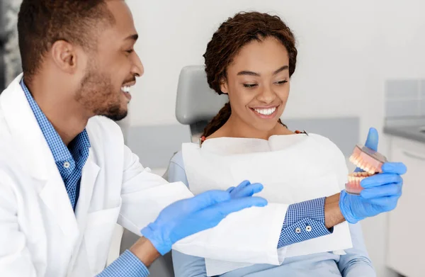 Dentista alegre educando seu paciente na clínica odontológica — Fotografia de Stock