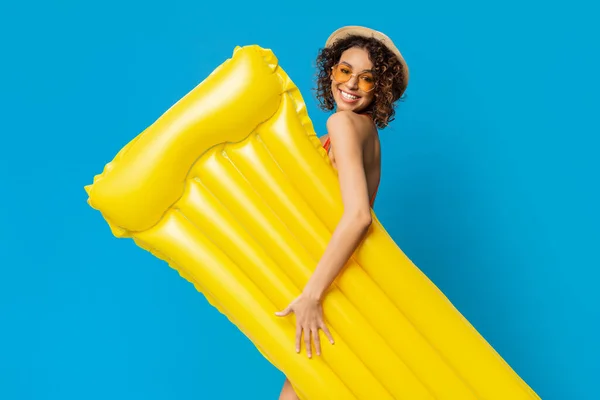 A nadar Joy. Menina africana positiva com colchão inflável amarelo sobre fundo azul — Fotografia de Stock